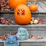 Assorted Halloween decorations guarding the front steps of a New England house.
