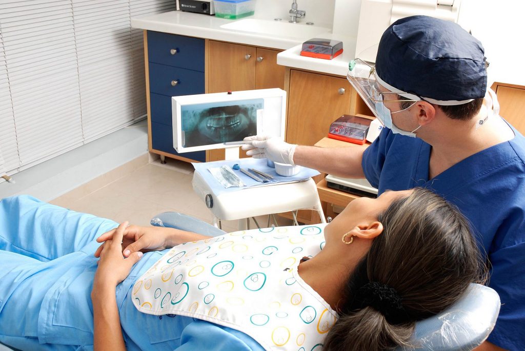 Patient looking at x-rays in a dentist chair, Source: Pixabay