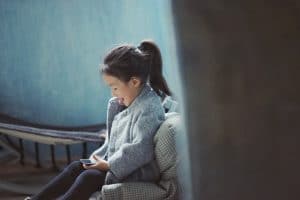 Young girl playing with a mobile phone, Source: Kyle Ford, HDDMag.com