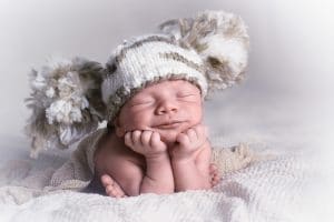Newborn baby photo with a beanie on its head, Source: Clara Morton, Sleeping Angels Co